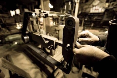 Les mains du coutelier à l'établi, façonnage d'une lame en acier carbone